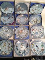 All twelve Haviland Limoges collector plates displayed in their original blue boxes, showing various holiday-themed designs.
