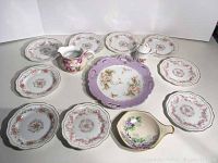 Full lot showing Dresden plate, nine Bavaria dessert plates, creamer, signed Austria dish, and lidded container arranged on a white background.