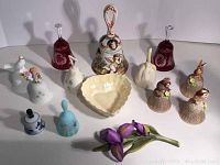 Overview displaying all bells and porcelain items arranged together on white background, showing variety of materials and sizes.