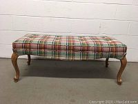 Front and top view of custom upholstered plaid bench seat against white wall and grey floor.