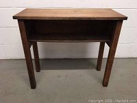 Front view of wood accent sofa table showing flat top and open lower shelf with straight legs against white wall background