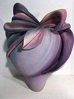 Front and side views of the large signed Sylvia Fugmann Bronco sculpture vase highlighting floral or leaf motif in pastel colors.