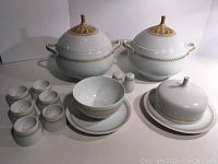 Full set shown including two lidded serving bowls, six ramekins with saucers, gravy boat, salt and pepper shakers and covered butter dish with plate.