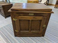 Front view of small oak TV cabinet stand with closed cabinet door and White Clad nameplate