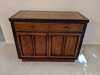 Front view of medium brown solid wood buffet server with drawer and two cabinet doors.