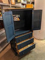 Front view of the cabinet with doors open revealing the interior space and drawers.