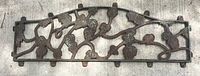 Full view of the cast iron decorative panel showing entire leaf and vine pattern, with mounting tabs visible.