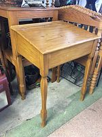 Full view of vintage solid wood slant top desk with four tapered legs and closed lid.