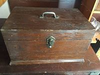 Closed wooden box with metal latch and handle