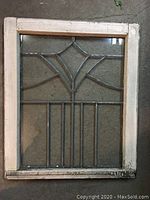 Full view of antique leaded glass window showing wooden frame and geometric leaded glass design