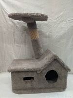 Front and angled views of the gray carpeted cat house tower with a scratching post wrapped in sisal rope and flat top platform.