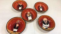 Five pasta and salad bowls with reddish-orange inside and waiter character illustrations.