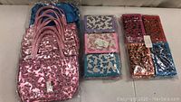 Lot of kids purses and wallets arranged in rows. Pink shiny purses with butterfly patterns on left, assorted color wallets with butterfly prints on right.