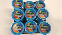 Top-down view of multiple blue-lidded containers of Glow Dough Rainbow arranged in rows.