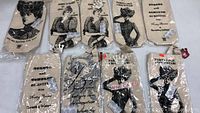 Ten fabric wine cases still in original plastic packaging with vintage ladies illustrations and text.