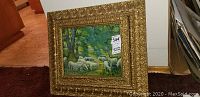 Front view showing gold ornate frame with pastoral sheep painting