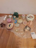 Overview of all items including perfume bottles, powder cases, pill case, and mirrors on bubble wrap.