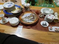 Full view of decorative plates, candle holders, figurines, and dishes on table