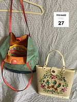 Two vintage tote bags on fabric background, showing colors and design details