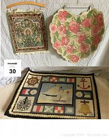 Overview of all three rugs showing hanging small floral rugs and nautical rug laid flat