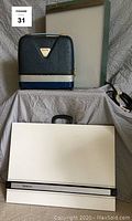 Photo showing the portable drafting table (white with carry handle), lite box with strap, and projection screen box.