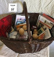 Wicker basket filled with sewing and craft items including wooden ornaments, CDs, and patterns.