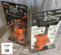 Two new Pony brand pipe clamp fixtures for 3/4 inch pipe in original packaging standing upright.