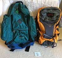 Front view of blue Kelty and yellow Osprey hiking backpacks showing compartments and design