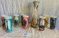 Front view of decanter and eight tumblers on cloth background