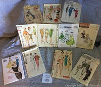 Photo showing assorted vintage sewing patterns from 1950s and 1960s, various brands and styles including blouses, skirts, dresses.