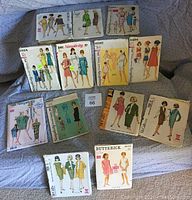 Photo showing eleven vintage sewing pattern envelopes from the early 1960s featuring illustrations of women's dresses and suits.