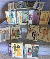 Wide view of the collection of vintage sewing patterns from the 1970s, laid out on a surface.