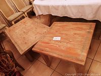 Photo shows rectangular coffee table and square end table made of rustic distressed wood with natural grain and knots visible, placed on tile floor beside dining chairs and table.
