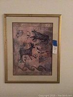 Framed wall art painting showing symbolic ancient-like script and animal figures.