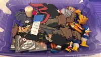 Overview photo showing Disney figurines and PlayStation games including Mickey Mouse gloves, various Disney character figurines, and multiple PS1/PS2 game cases.