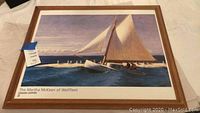 Framed print of Edward Hopper's "The Martha McKeen of Wellfleet," showing a sailboat on water with people onboard in a wooden frame.
