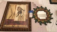 Monkey print wall art and flower-shaped round mirror displayed on a table