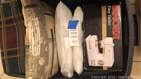Singer Tiny Tailor sewing machine box beside pillows with a beige geometric patterned pillow and two white pillows.
