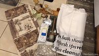 Full display of shower curtains, bath accessories, decor, and cleaning tools on tiled floor