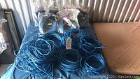 Overview of the loose coiled blue Cat5 network cables spread out on a table covered with a blue cloth.