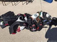 Photo showing the hockey protective gear including chest protector, gloves, elbow pads, shin guards, and pants spread on the ground.
