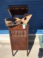 Front view of Victrola cabinet with lid open and stack of records on top
