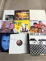 Photo showing multiple vinyl record covers together including Heaven 17, Howard Jones, New Edition, Men At Work, and others.