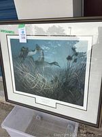 Framed print depicting ducks in marsh grasses and water, showing overall artwork and frame.