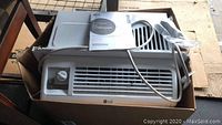 Boxed LG window air conditioner unit showing front vent and control dial.