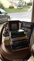 Books, dolphin statue, photo tissue box on stacked chairs with outdoor background.