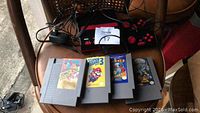 Four original Nintendo NES game cartridges displayed, including Donkey Kong, Super Mario Bros. 3, Donkey Kong Jr., and one additional cartridge.