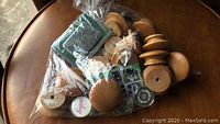 Bag containing multiple vintage wooden cabinet knobs, some knobs have round and some have uniquely shaped tops, various sizes.