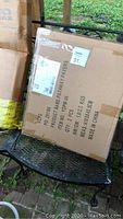 Two cardboard boxes labeled Concrete Pathway Pavers, with shipping labels and manufacturing details visible.