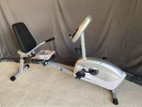 Side view of silver Schwinn A2S recumbent bike showing black padded seat and frame
